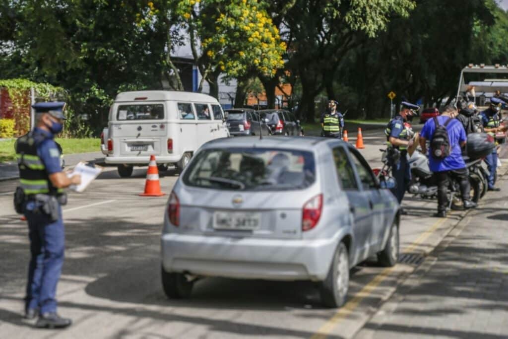 Blitz policial com fiscalização de veículos em rua movimentada