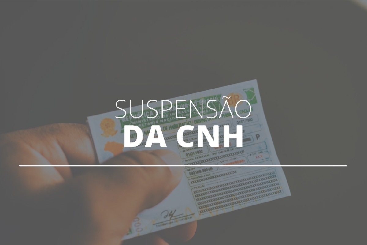 Mão segurando CNH suspensa.