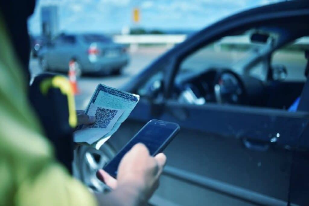 Policial verifica documento de carro em estrada